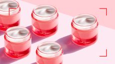 pots of eye cream with a pink and red colored background