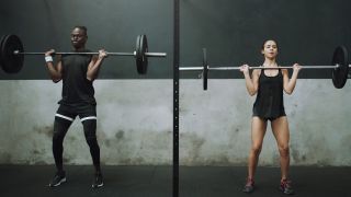 Man and woman performing the clean and press, about to press the barbell overhead