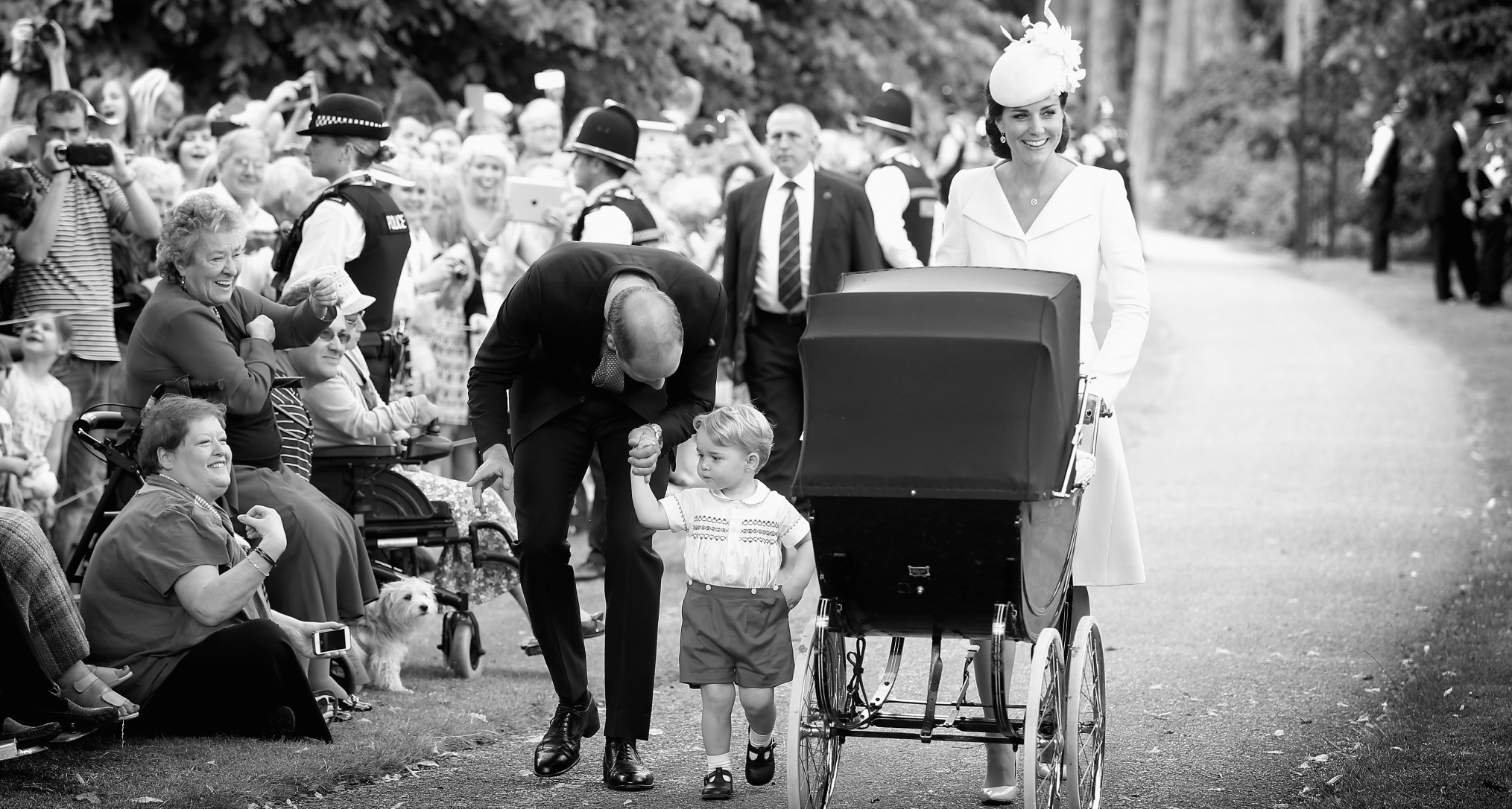 Prince William and Princess Kate walking with Prince George and Princess Charlotte, in a stroller, to her christening