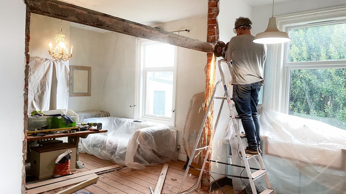 Man removing a metal beam in a living room