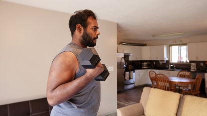 Man working out with dumbbells at home