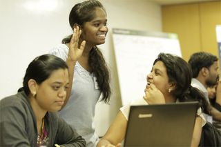 A group of women working at a laptop