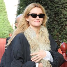 Sarah Pidgeon wearing a fur-trimmed black coat, light-wash jeans, a cognac Balenciaga Rodeo Bag, and black ankle boots
