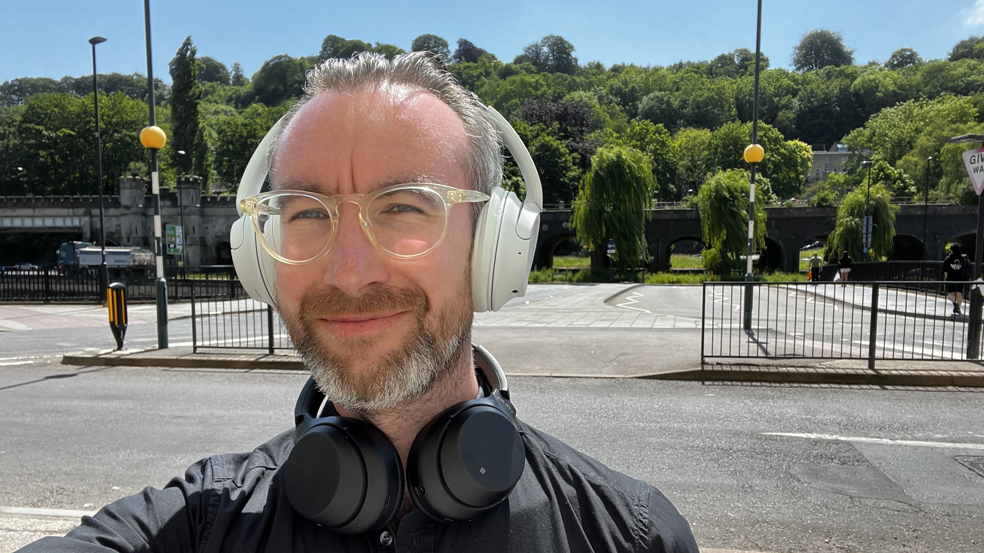 Sony WH-CH520N headphones worn by TechRadar Editor Matthew Bolton, near a road, who has a pair of Sony WH-1000XM3 headphones around his neck too