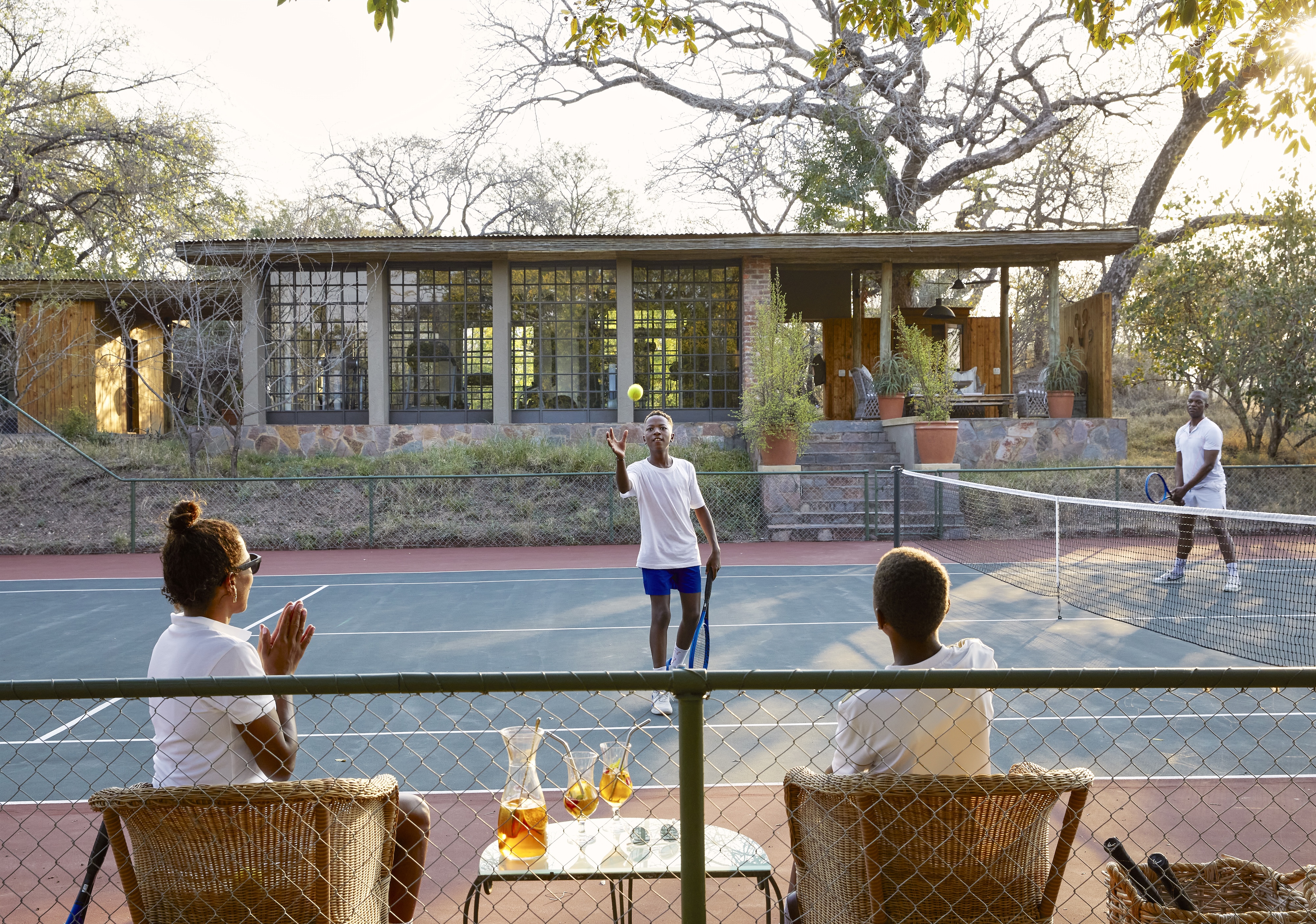 A family plays tennis on the court at Singita Castleton