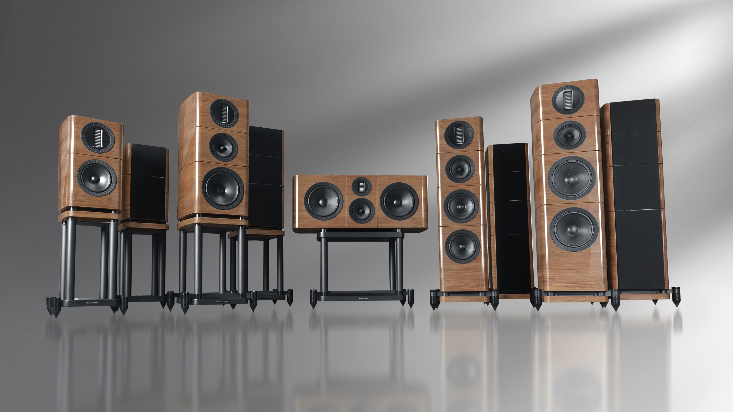 Wharfedale Elysian R series of speakers in walnut on a grey background