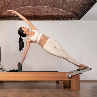 woman using Reformer Pilates machine