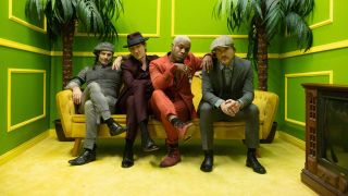 Vintage Trouble sitting on a sofa in a bright green room