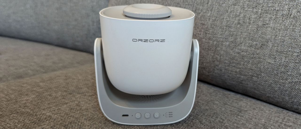 Orzorx galaxy lite star projector on a fabric grey backdrop