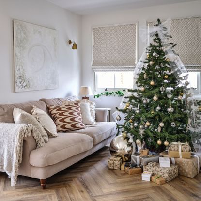 White living room with pink sofa, christmas tree and white tulle