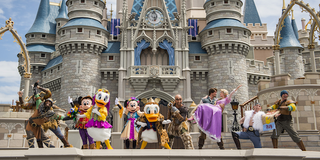 Disney characters pose in front of the Castle at Walt Disney World