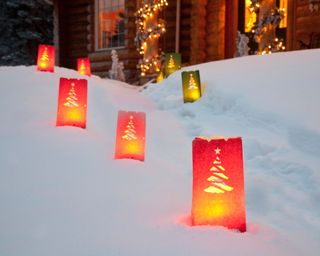 Log home decorated with Christmas lights and luminaries on the walkway, Anchorage, Alaska