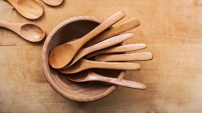 Wooden spoons in bowl on wooden counter