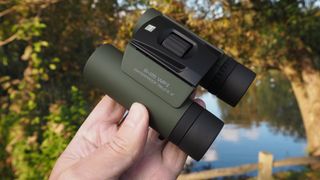 Close up photo of the Olympus 8x25 WP II binoculars in the hands of the author