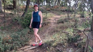 Julia Clarke on forest trail wearing Montane Women's Ineo Lite shorts