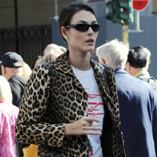 Vittoria Ceretti photographed in Milan between shows during Milan Fashion Week wearing Prada Montecarlo Re-Edition 2005 Suede-Trimmed Mesh Sneakers in yellow. 