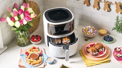 Aldi air fryer with viewing window on kitchen worktop surrounded by cooked dishes
