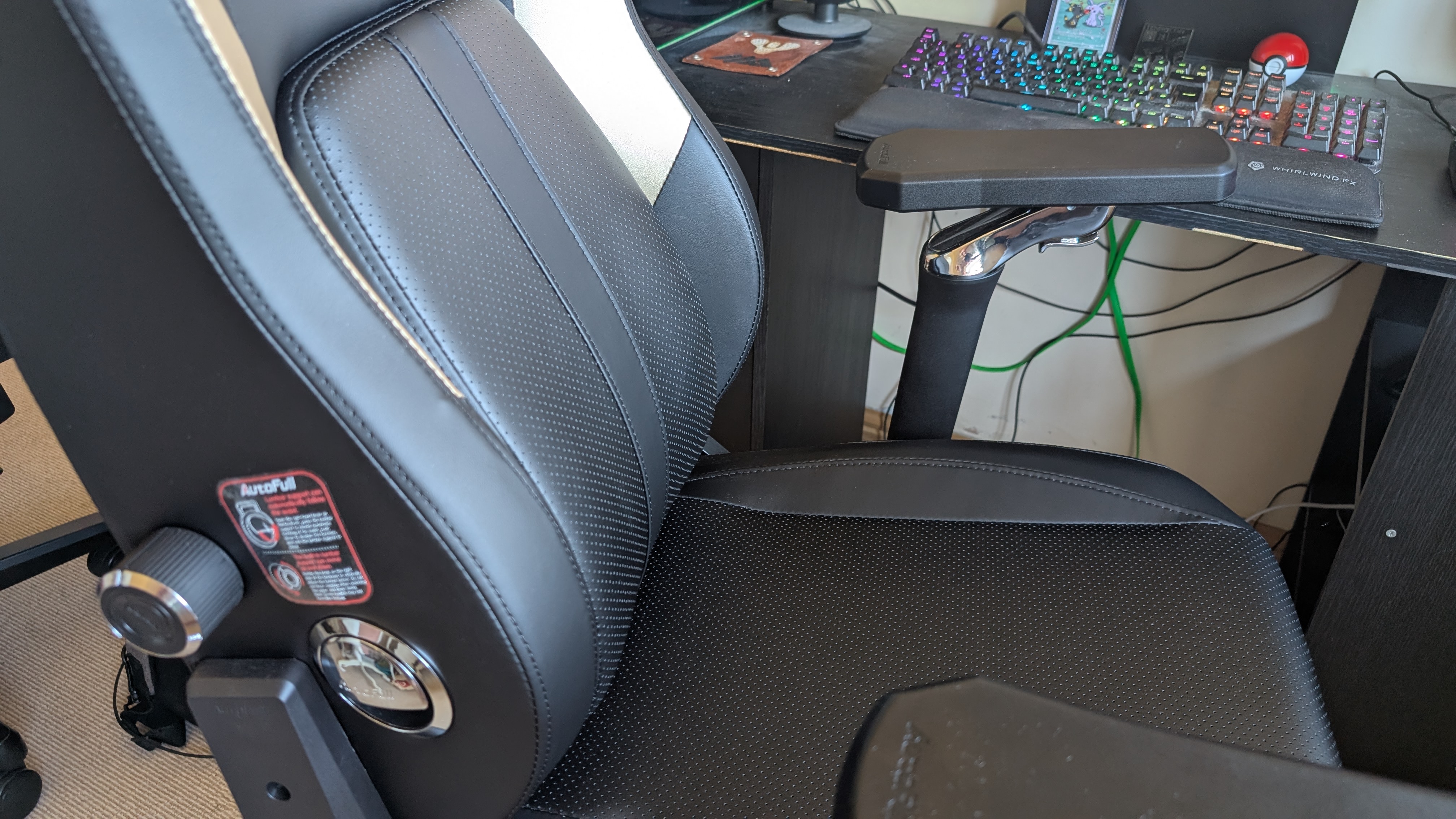 The AutoFull M6 Ultra gaming chair pictured in front of a desk with a gaming PC setup.