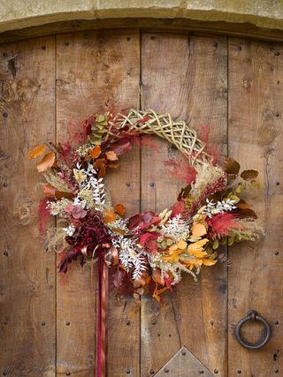 Autumn wreath made of wicker based leaves/autumn leaves on rustic door