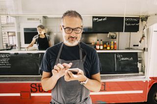 Man uses mobile POS system outside of food truck