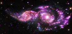 This composite image of the grazing galaxies NGC 2207 and IC 2163 contains data from NASA's Chandra, Hubble and Spitzer space telescopes. (Chandra data shows up as pink, Hubble data as red, green and blue, and Spitzer data as red.)