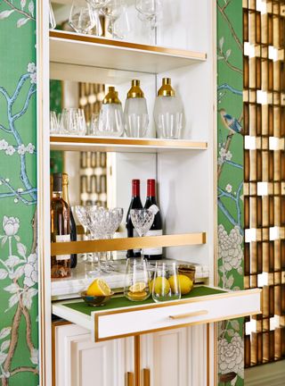 Small home bar with pull out drawers and pretty wallpaper