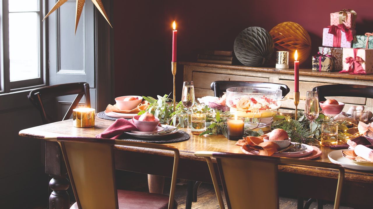 A burgundy-painted dining room with a Christmas-decorated dining table