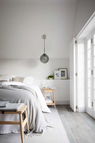 grey bedroom with pendant light and wood bedside table