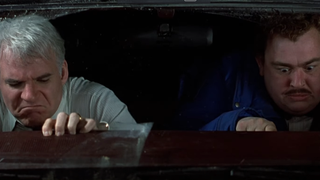 John Candy and Steve Martin remove their fingernails from the car after moving too far forward.