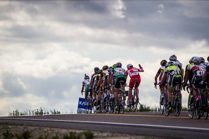 Riders pass over the climb and into the feed zone