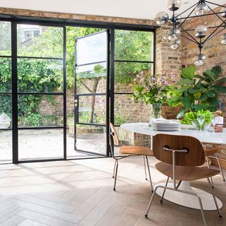 dining area with upvc bifold doors with black frame and brick wall