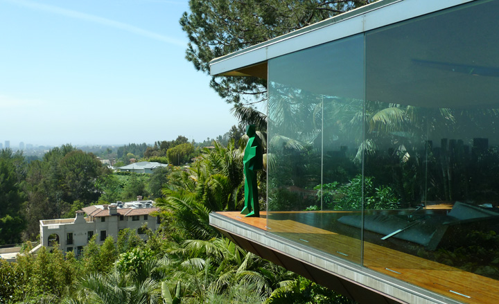 Prismatic, green figure overlooks the surrounding landscape