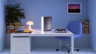 Ghost Core AI PC sat on a table in a home office, next to a record player and lamp
