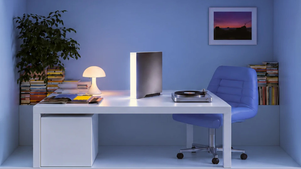 Ghost Core AI PC sat on a table in a home office, next to a record player and lamp