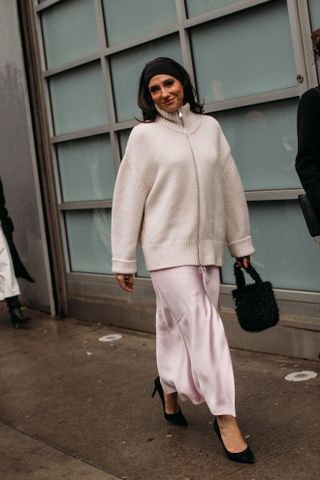 woman wearing sweater, skirt, and kitten heels