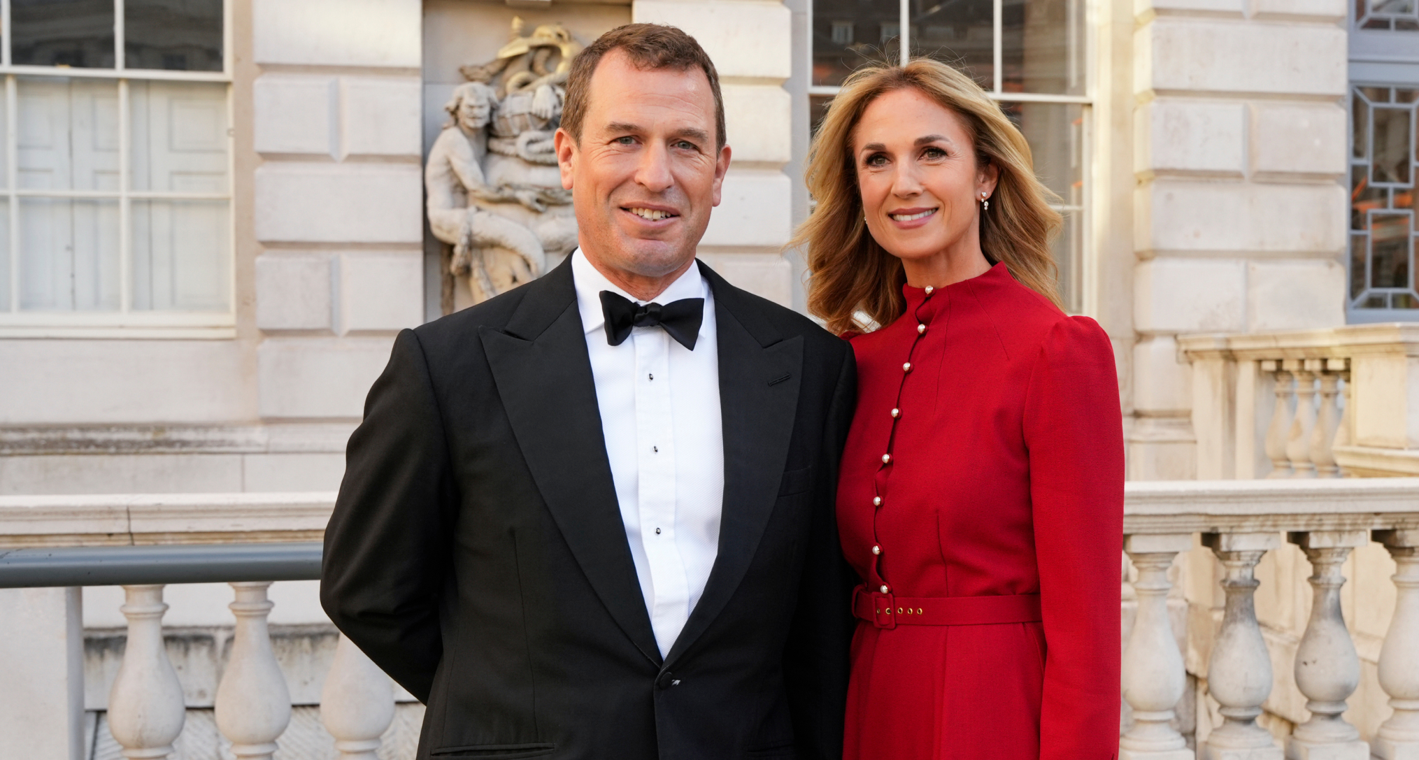 Harriet Sperling wearing a red dress standing next to Peter Phillips, wearing a tux
