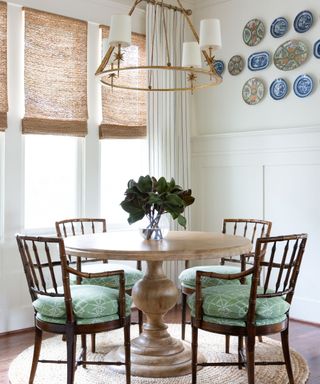 Small dining room corner with a round table and a wall of carefully selected plates