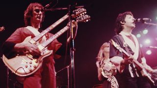 Denny Laine (left) and Paul McCartney perform onstage in 1976