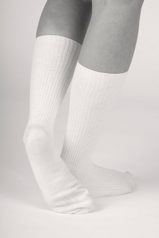 black and white image of someone feet from behind wearing white socks
