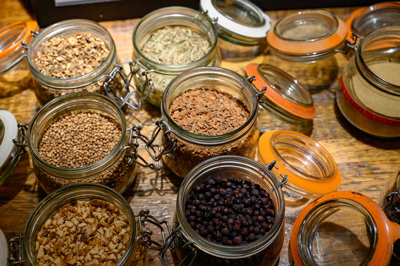 Botanicals for infusion can include dried orange peel and juniper berries, as in the bottom two jars pictured. Credit: iStock/Getty Images Plus