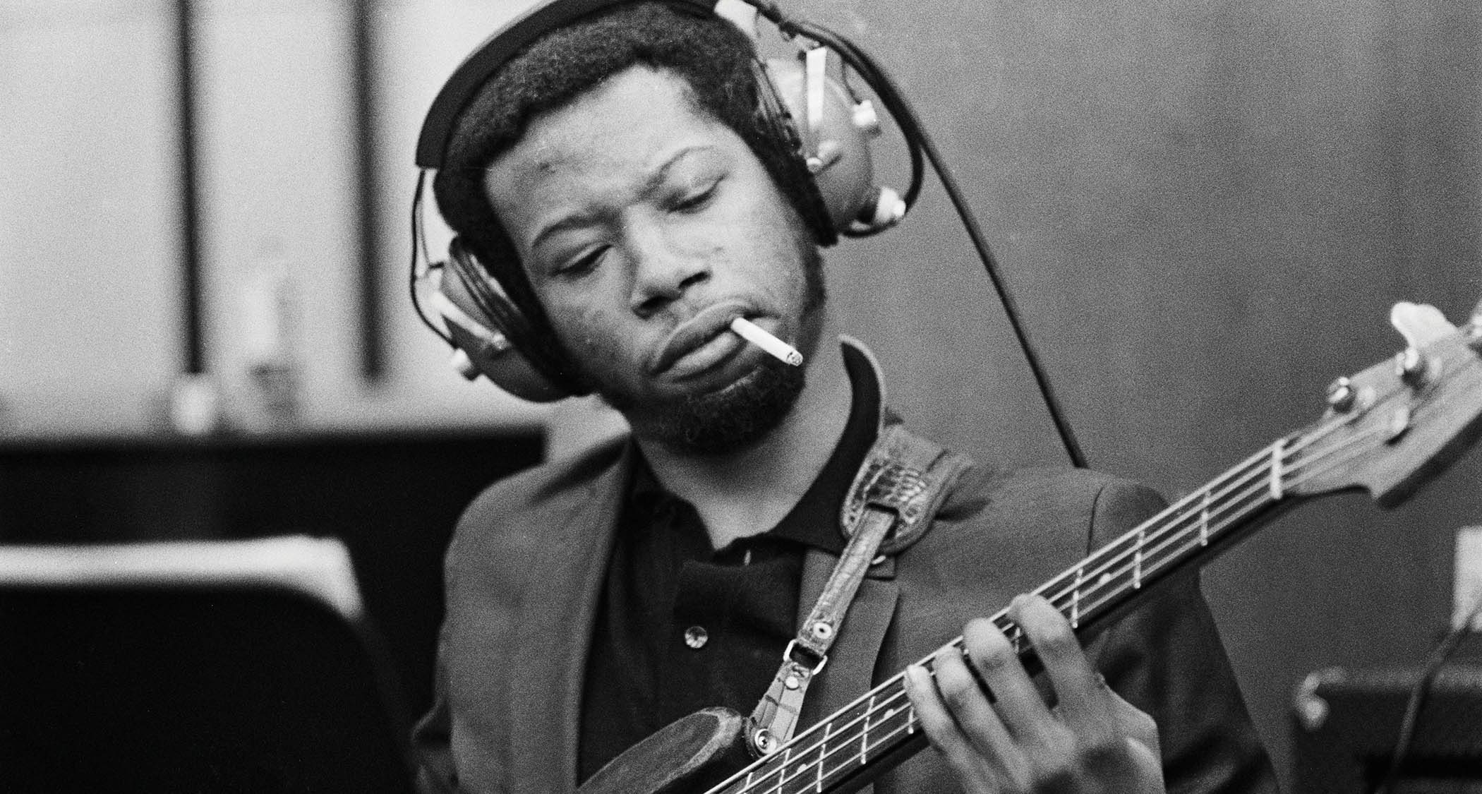 A black-and-white action shot of Jerry Jemmott smoking a cigarette while laying down a bass track