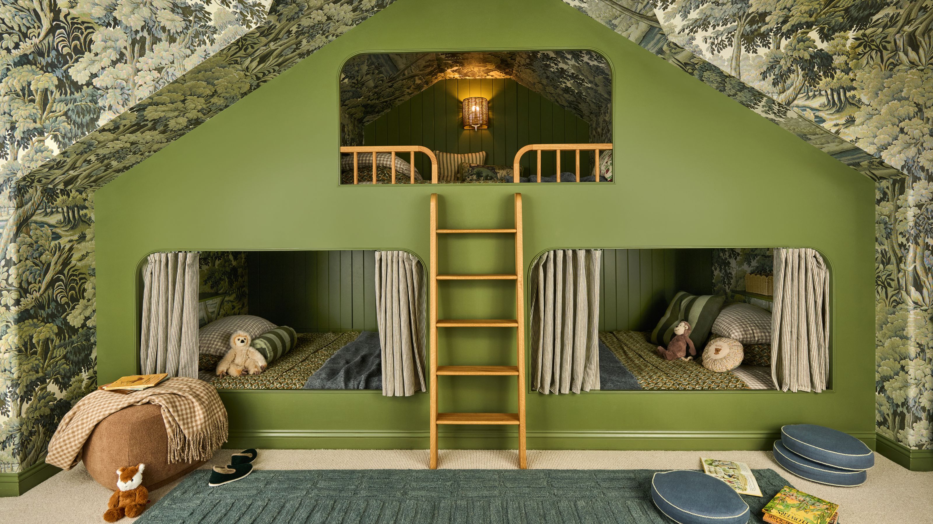 a vaulted attic room with tree wallpaper across walls and ceiling with a custom green painted triple bunk bed for kids