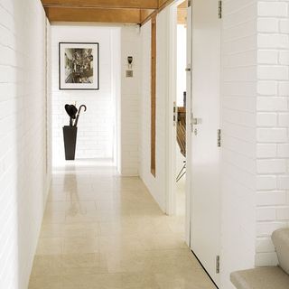 hallway with white wall and tiles floor