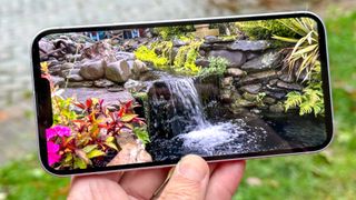 iPhone 14 Plus display showing video of waterfall