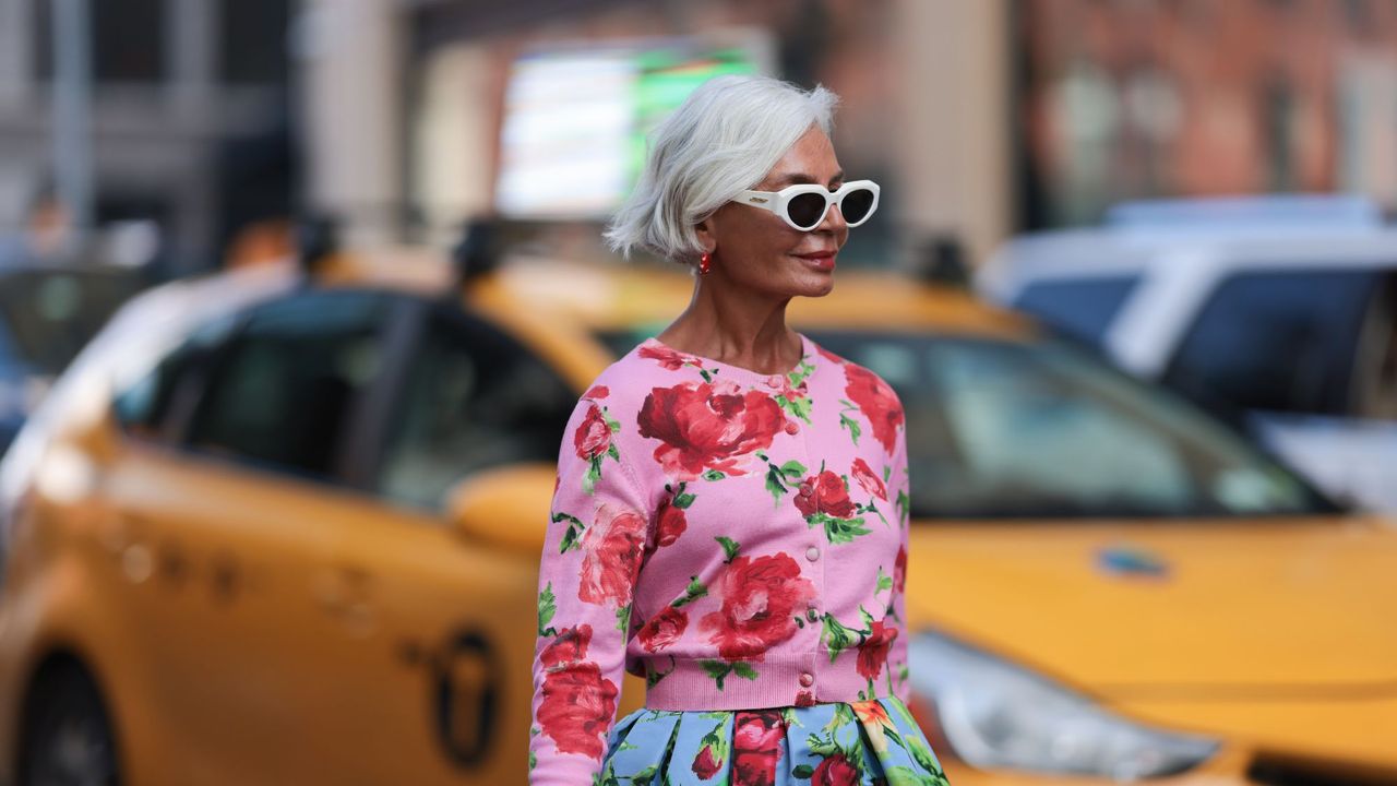 Bond repair hair products - Grece Ghanem is seen wearing sunglasses with white frame from Bottega Veneta, red hoop earrings with pearls, a pink cropped cardigan with red/green flower pattern - gettyimages 1681233409