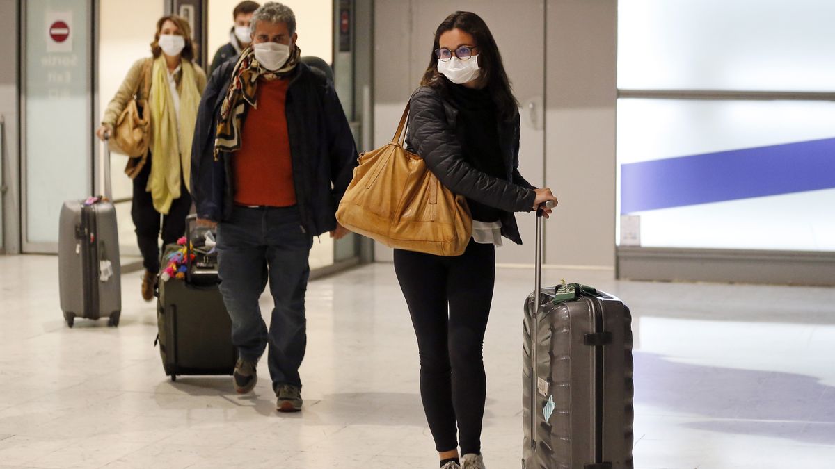 Passengers wear protective masks after landing at Charles De Gaulle Airport on Feb. 10, 2020 in France. Places like airports, bus stops and gas stations are especially risky during the coronavirus pandemic.