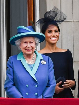 Queen Elizabeth ll and Meghan, Duchess of Sussex stand on the balcony of Buckingham Palace