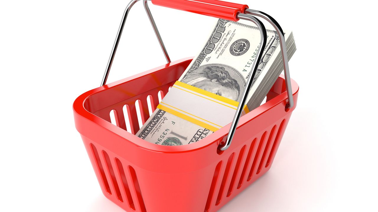 A stock of hundred-dollar bills in a red shopping basket.