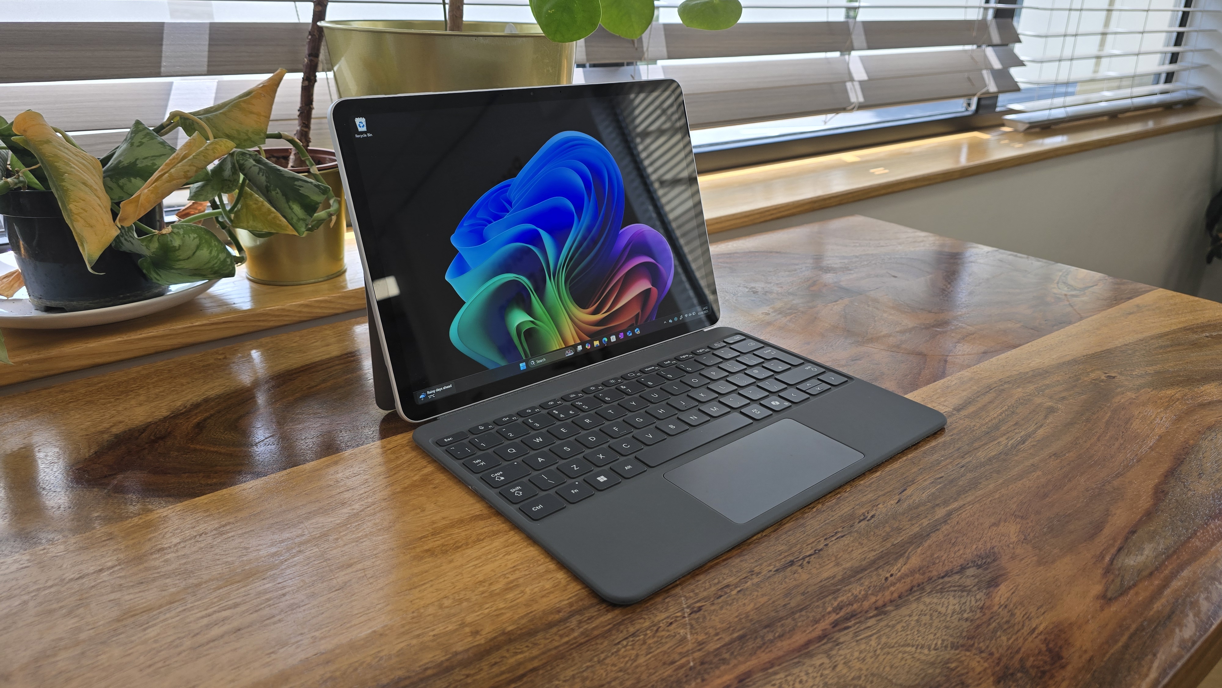 Microsoft Surface Pro 12 tablet on wooden table in relaxed cafe