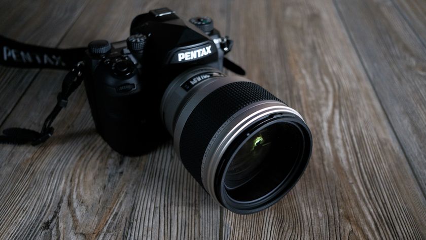 The Pentax 85mm f/1.4 SDM AW on a wood background
